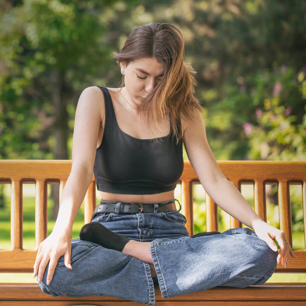 Genç ve çekici bir kadın parkta meditasyon yapıyor.. - Fotoğraf, Görsel