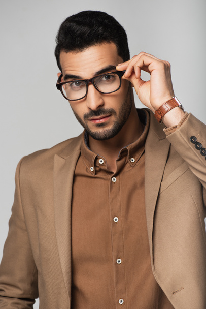 Arabian businessman holding eyeglasses and looking at camera isolated on grey  - Foto, immagini