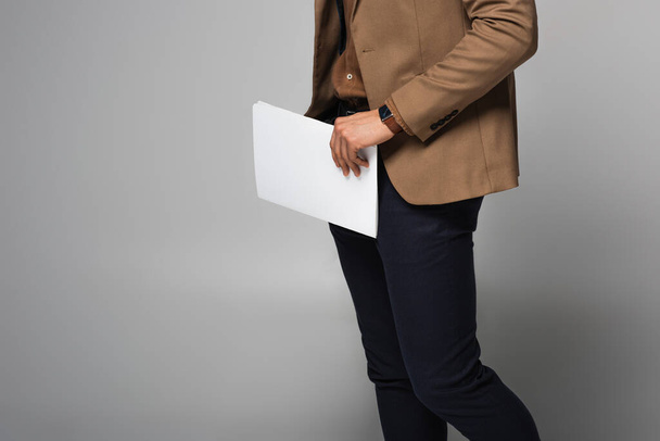 Cropped view of businessman holding documents isolated on grey  - Photo, image