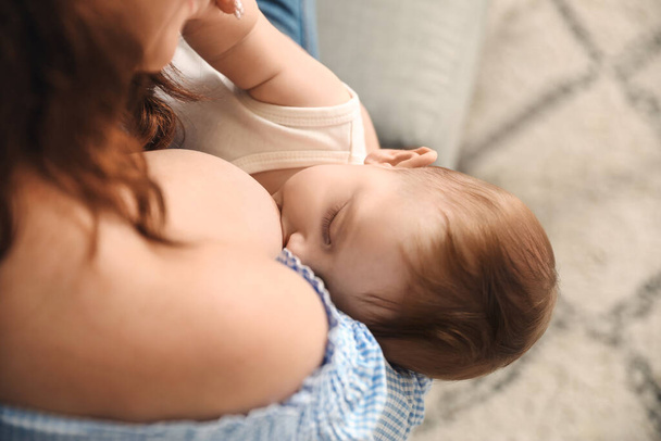 Jovem mulher amamentando seu bebê em casa, close-up - Foto, Imagem