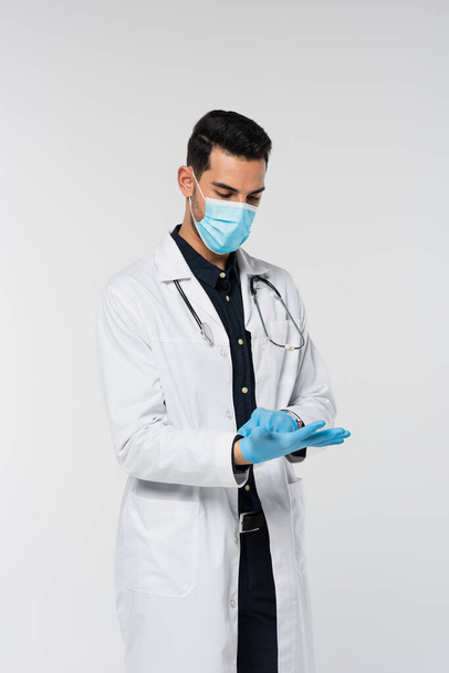 Muslim doctor in medical mask wearing latex gloves isolated on grey  - Photo, image