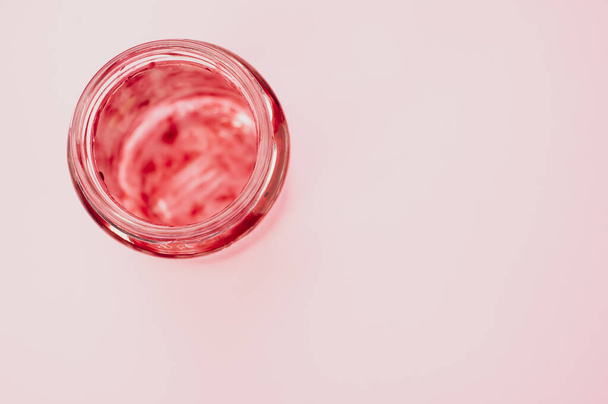 A top view of an empty strawberry jam jar isolated on light pink background - Valokuva, kuva