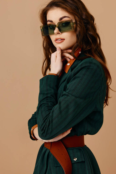 mulher atraente usando óculos de sol posando moda estilo de vida fundo bege - Foto, Imagem