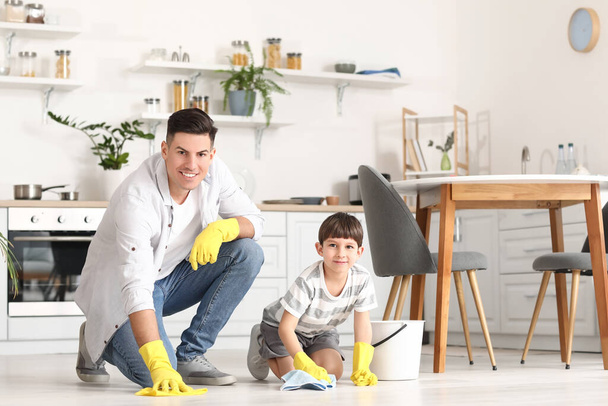 Отец и сын чистят пол на кухне - Фото, изображение