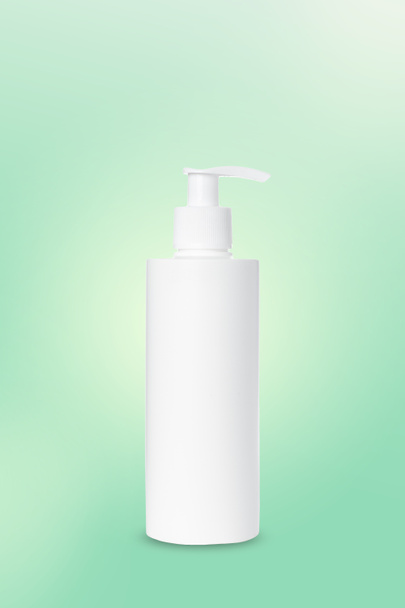 empty white plastic pump bottle for cosmetics on green background. Mockup. Container for liquid cream, lotion, serum, medication - Photo, Image
