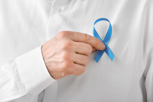 Man with blue ribbon, closeup. Prostate cancer awareness concept - Foto, afbeelding