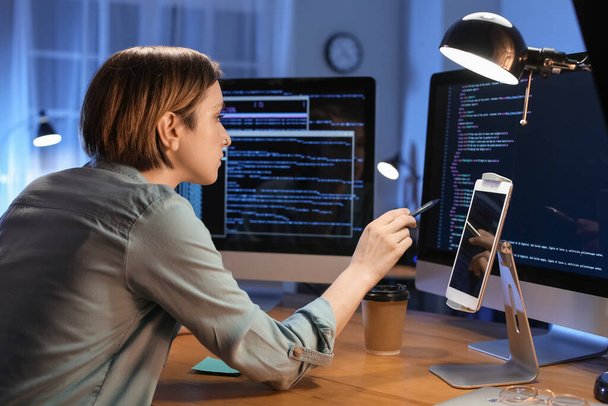 Женщина-программист, работающая ночью в офисе - Фото, изображение