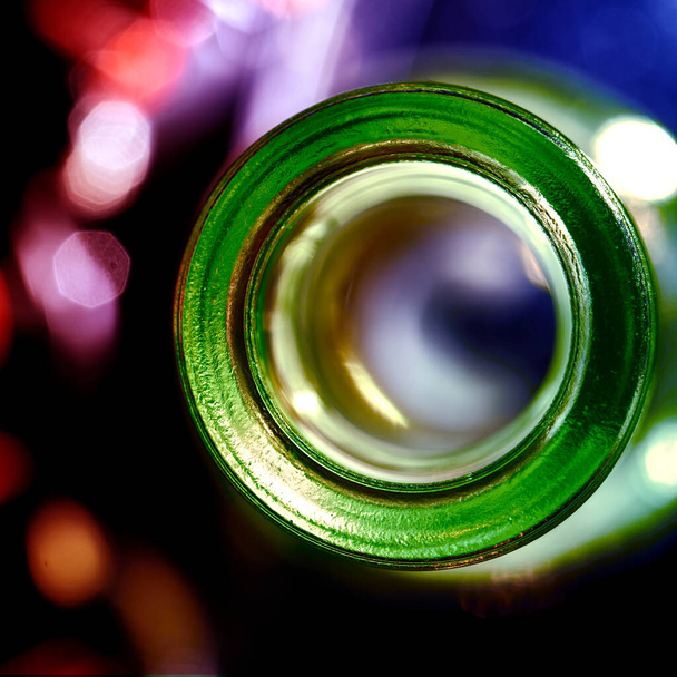 A closeup shot of an empty glass bottle opening with a bokeh background - Фото, изображение