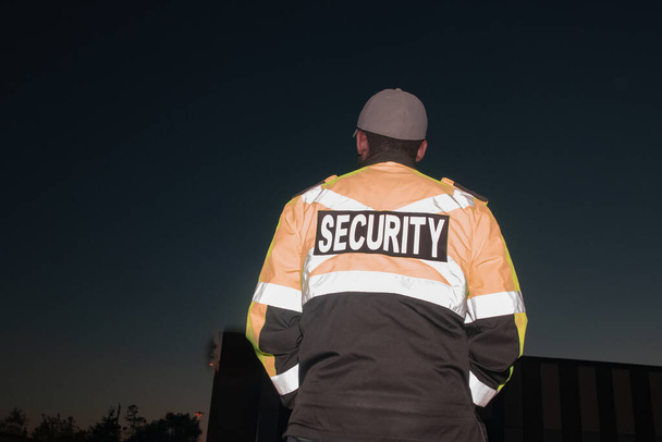 A closeup shot of a security guard patrollingbusy street and city at sunset  - Foto, immagini