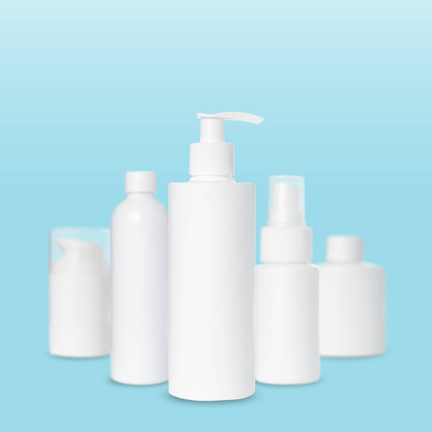 prázdné bílé plastové láhve pro kosmetiku na modrém pozadí. Mockup - Fotografie, Obrázek