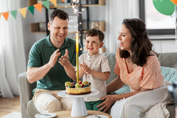 ευτυχισμένη οικογένεια με τούρτα γενεθλίων στο σπίτι - Φωτογραφία, εικόνα