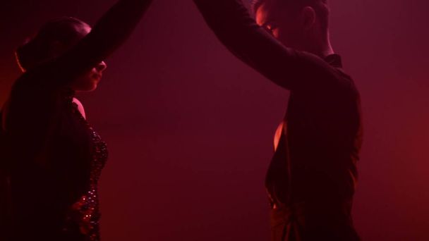 Dancers performing latin dance red light background. Ballroom couple dancing. - Photo, Image