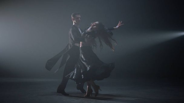 Ballroom dancers performing indoors. Beautiful dance couple spinning on stage. - Foto, imagen