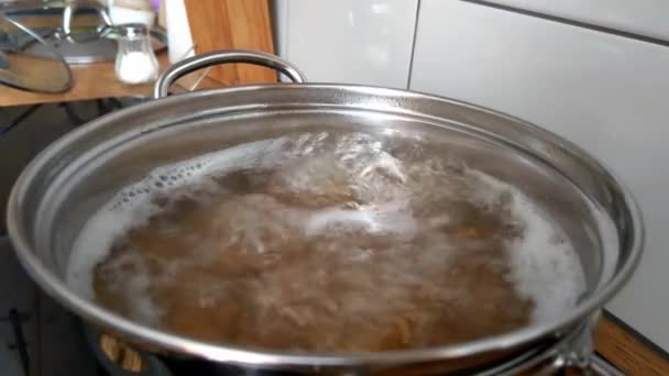 Cooking pasta in boiling water in a saucepan - Footage, Video