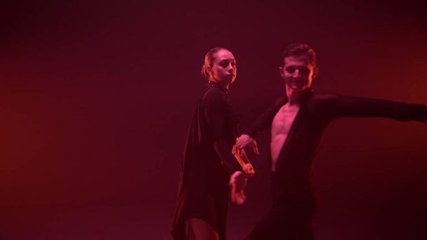 Viehättävä pari tanssimassa latinotanssia sisätiloissa. Mies ja nainen tanssivat studiossa. - Valokuva, kuva