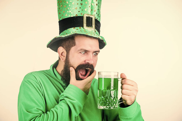 Man brutal bearded hipster drink pint beer. Green beer mug. Drinking beer part of celebration. Irish pub. Alcohol consumption integral part saint patricks day. Discover culture. Irish tradition - Фото, изображение