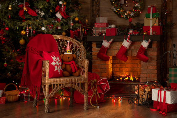 Fireplace and Christmas tree background. Festive interior inside wooden house, New Year's cheerful mood Spirit of Christmas.  - Фото, изображение