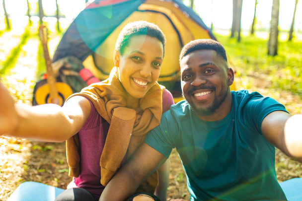 afro latin couple in tent taking selfie using modern smartphone - Fotoğraf, Görsel