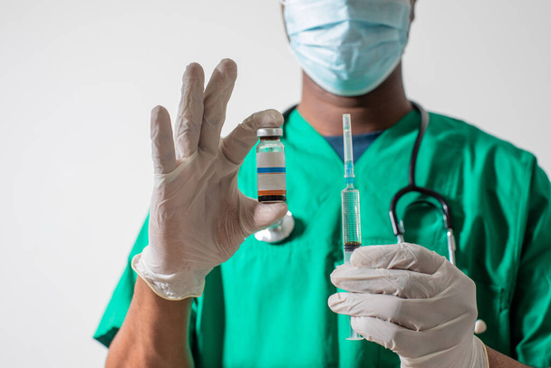 Doctor in medical mask holding syringe with medication - Foto, Imagem