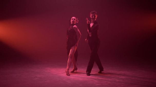 Nádherný muž a žena tančí na osvětleném jevišti. Taneční pár představení. - Fotografie, Obrázek