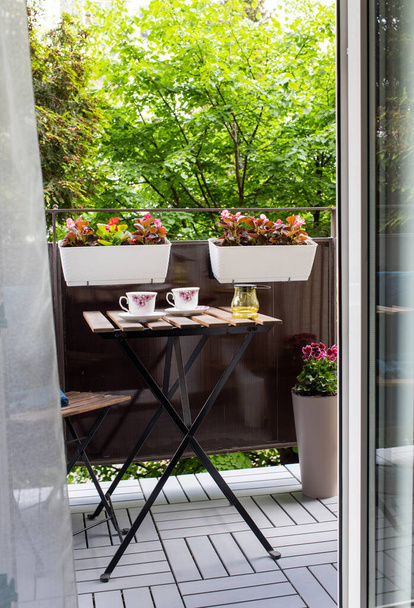 светлая терраса летом с цветами и журнальным столиком - Фото, изображение
