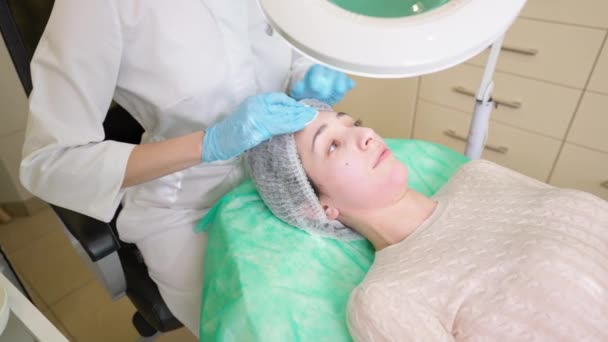 Esteticista preparando o rosto da mulher antes do procedimento de beleza de cuidados com a pele na clínica - Filmagem, Vídeo