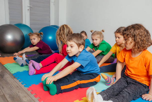 Children exercising while physical education lesson at preschool - Fotoğraf, Görsel