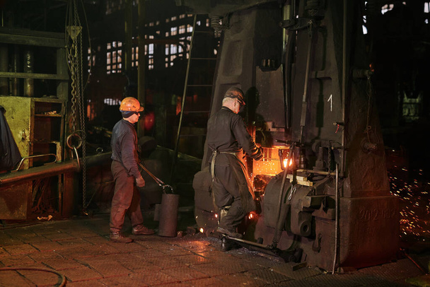Trabajador en ropa de trabajo protectora que opera en la planta metalúrgica - Foto, imagen