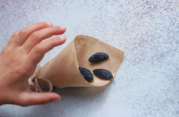 hands of a child with a paper bag with a honeysuckle berry - Fotoğraf, Görsel