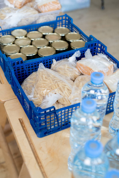 Група пластикових коробок з продуктами харчування та пляшками води на столі
 - Фото, зображення