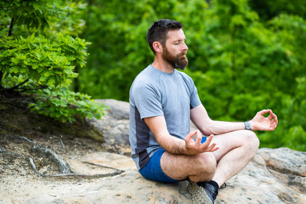 fiatal férfi meditál a szabadban  - Fotó, kép