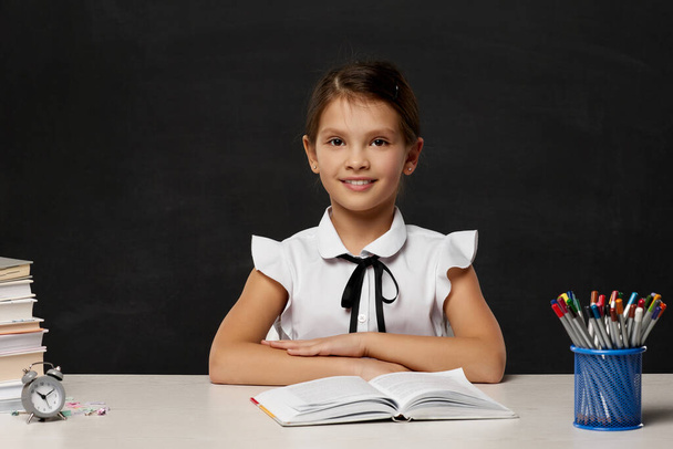 aranyos kislány olvasás egy könyvet az osztályteremben - Fotó, kép