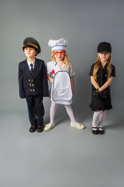 The little kids pose in the costumes of different profession - Φωτογραφία, εικόνα