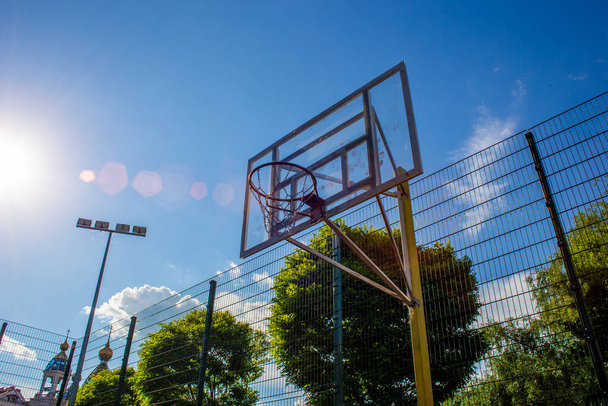 Basketball-Backboard mit einem Ring auf der Straße auf dem Spielplatz vor dem Hintergrund des Himmels - Foto, Bild