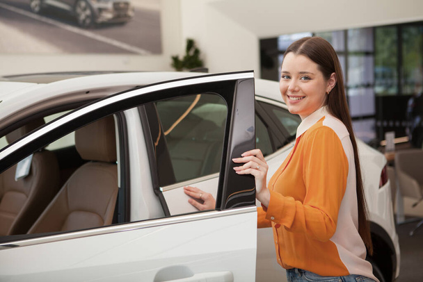 Upea onnellinen nuori nainen ostaa uuden auton jälleenmyyntisopimuksen, kopioi tilaa - Valokuva, kuva