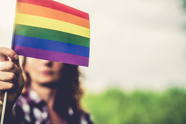 žena držící duhovou vlajku LGBT - Fotografie, Obrázek
