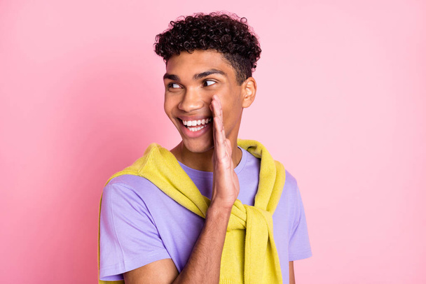 Photo of young cheerful afro guy happy positive smile look empty space tell gossip secret isolated over pink color background - Foto, immagini