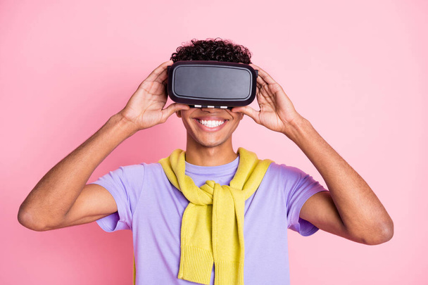 Photo of young happy cheerful positive african man in vr-glasses wear jumper on shoulders isolated on pink color background - Zdjęcie, obraz