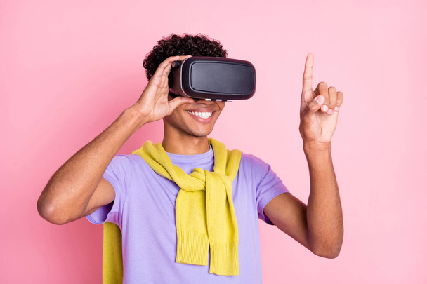 Photo of young african guy happy positive smile wear virtual reality glasses look finger isolated over pastel color background - Фото, изображение