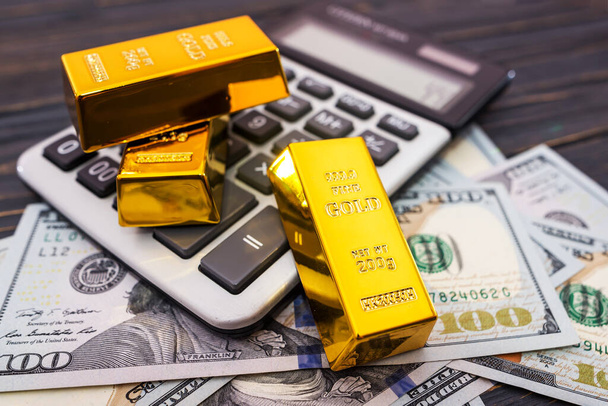 Крупним планом золоті смуги з доларами і калькулятор
. - Фото, зображення