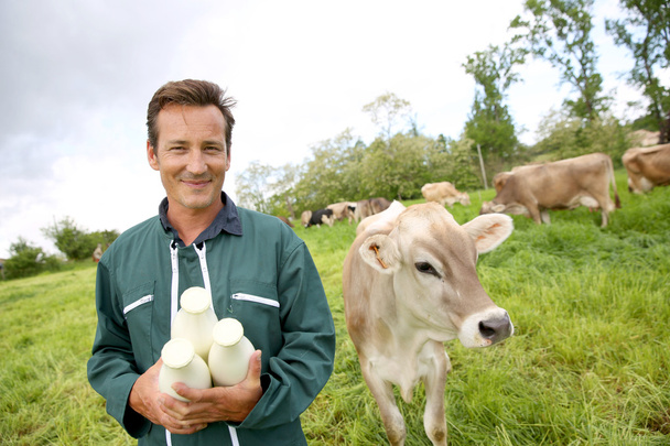Фермер тримає пляшки молока
 - Фото, зображення