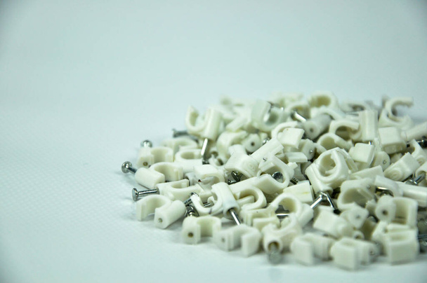 Pinzas de cable de plástico con clavos de hormigón aislados sobre fondo blanco - Foto, imagen