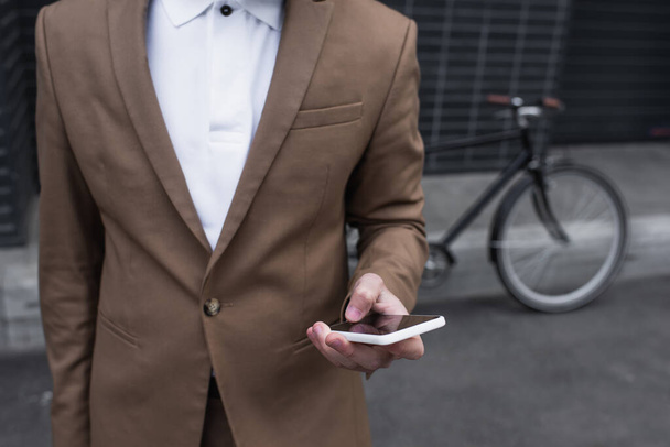 rajattu näkymä nuori liikemies muodollinen kulumista käyttämällä älypuhelin ulkopuolella - Valokuva, kuva