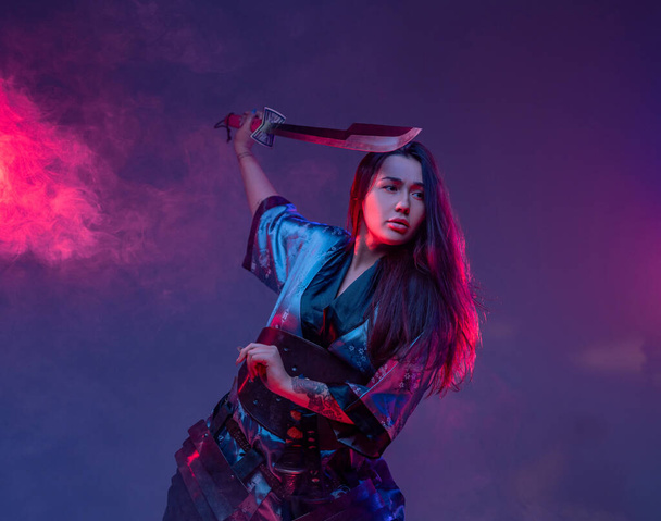 Mujer oriental con espada samurai en posición de lucha - Foto, Imagen
