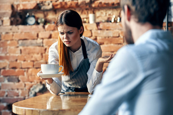 жіночий офіціант з чашкою кави, що обслуговує клієнтське кафе
 - Фото, зображення