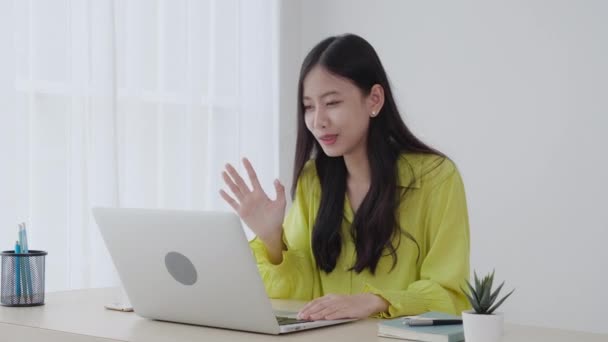 Молодая азиатская бизнес-женщина, использующая ноутбук для видеоконференции онлайн с социальной дистанцией, деловая женщина, работающая с видеозвонком, новой нормальной, связи и работы из дома концепции. - Кадры, видео