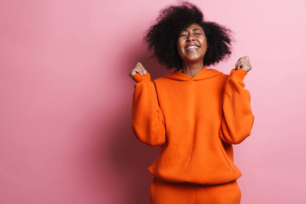 Excited african american woman screaming and gesturing on camera isolated over pink background - Foto, imagen