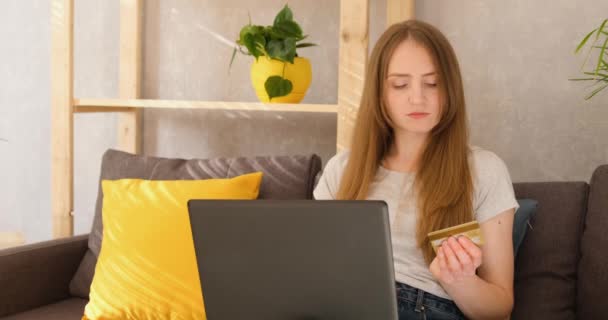 A fiatal nő beírja a hitelkártya adatait a laptopba. Online vásárlás és fizetés a vásárlásért. - Felvétel, videó