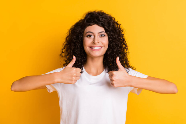Photo of young beautiful smiling positive lovely pretty girl showing thumb-up isolated on yellow color background - Foto, immagini