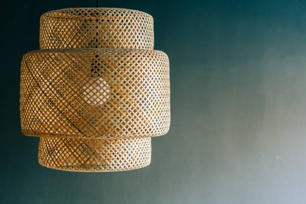 Wicker lamp hanging from the ceiling gray background - Photo, Image